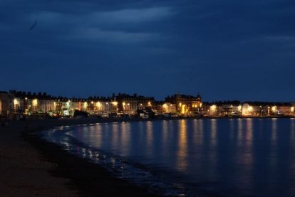 De nacht valt in de baai van Weymouth.