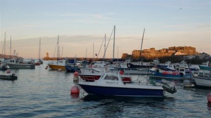 De wir-war van bootjes op weg naar het wachtponton van St.Peter Port
